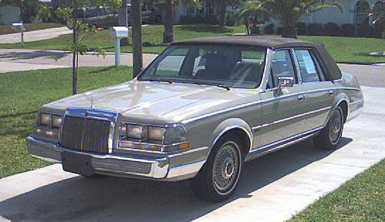 Silver 1980s Lincoln Continental sedan with vinyl top parked on driveway, 3q-front view
