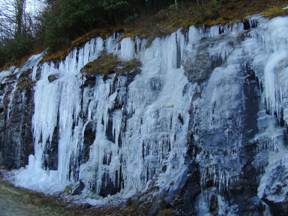 Frozen icicles covering a roadside rock embankment