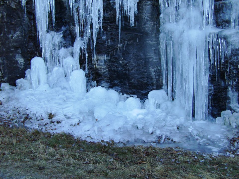 Mounded ice and icicles at the base of a rock face
