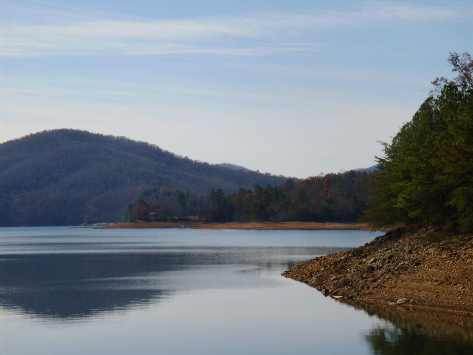 Lake with forested mountains and rocky shore