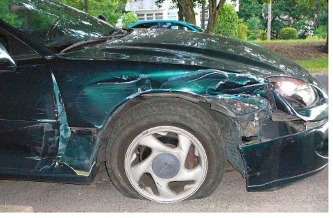 1996 Dodge 1500 - This green car sustained significant damage to its front fender and has a flat tire.