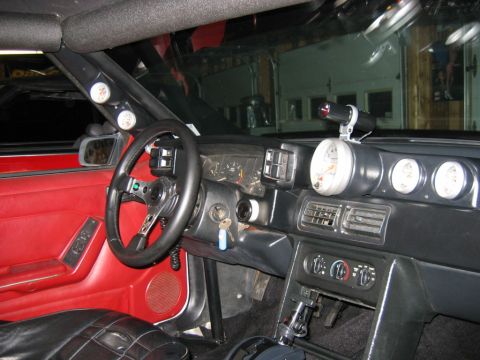 1992 Ford Mustang - The interior of a car shows a custom steering wheel and multiple gauges on the dashboard.