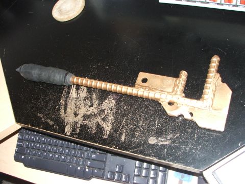 1965 Ford Mustang - A metal component, possibly a tool or a vehicle part, is shown on a desk next to a keyboard.