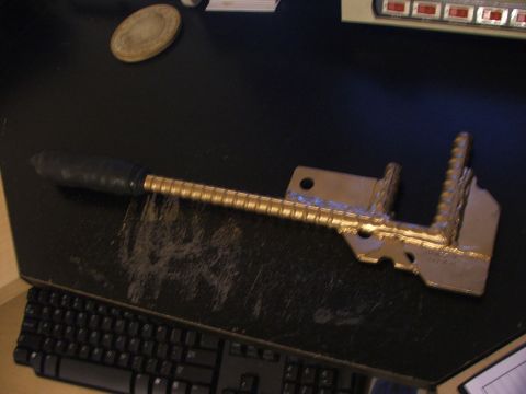 1965 Ford Mustang - A metal tool with a black handle and threaded shaft is placed on a desk next to a computer keyboard.