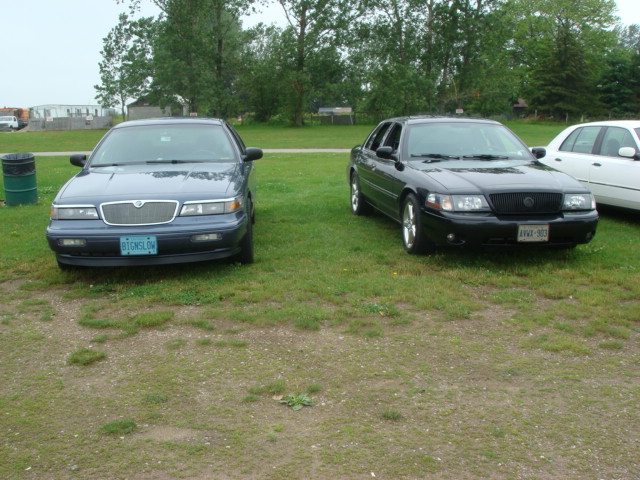 Front view of a blue Mercury Grand Marquis and a black Mercury Marauder parked side-by-side