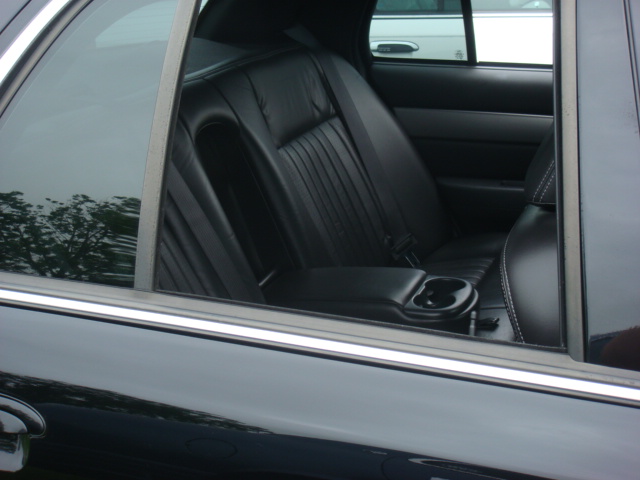 Black leather rear car seats with cup holder and seatbelt