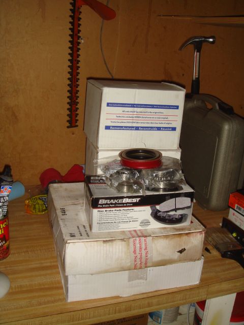 1992 Ford Bronco - Several boxes of automotive brake parts, including disc brake pads and wheel bearings, are stacked on a wooden surface.