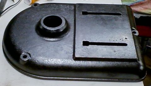 1995 Ford Bronco - A dark metal part with a circular opening and two elongated slots is shown.