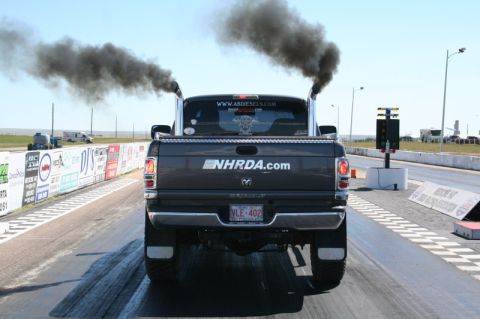2002 Dodge 2500 - A Dodge 2500 truck with dual exhaust pipes spews black smoke while on a drag strip.