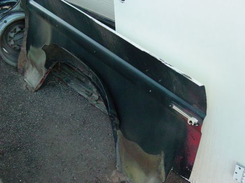 1979 Ford Bronco - A damaged vehicle fender and wheel are shown, with rust visible on the metal.