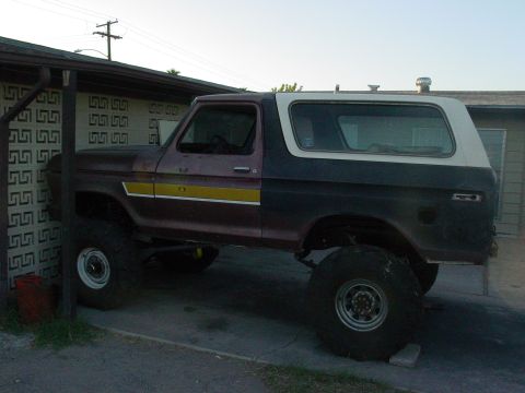 1979 Ford Bronco - This lifted Ford Bronco has a two-tone paint scheme and a yellow stripe along the side.