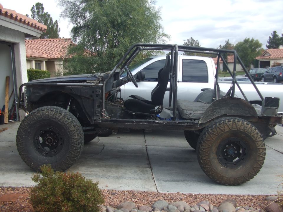 Side view of a heavily modified off-road vehicle with a roll cage and large tires