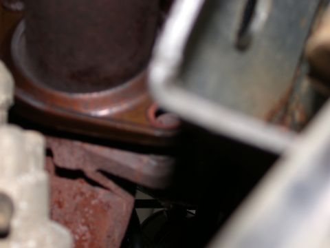 2000 Ford Crown Victoria - A close-up view of a corroded exhaust pipe flange and bracket assembly.