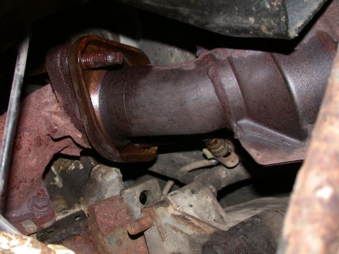 2000 Ford Crown Victoria - Close-up view of a corroded exhaust pipe connection, showing significant rust and wear.
