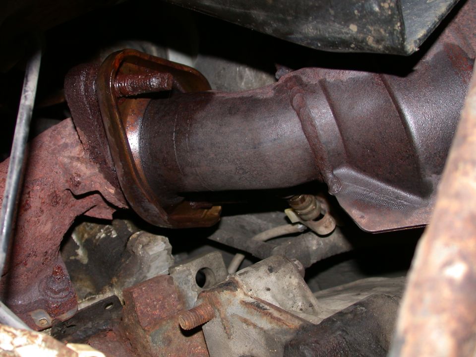 Rusty exhaust pipe flange connection with bolts and a sensor wire
