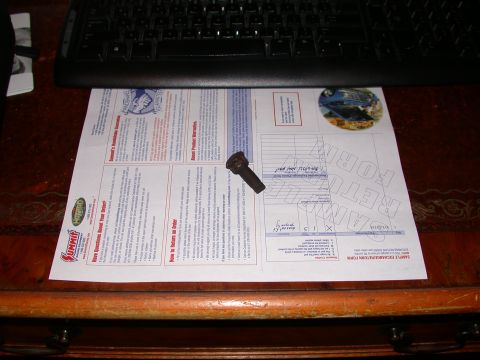 2000 Ford Crown Victoria - A single exhaust bolt rests on a return form, with a keyboard visible above.