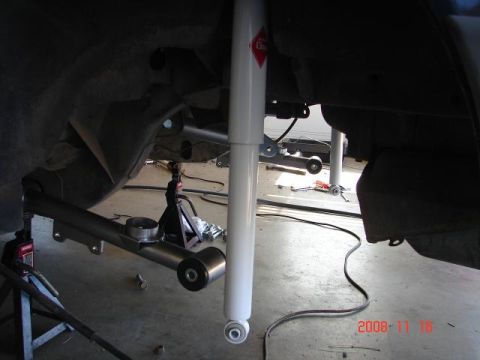 1985 Ford Mustang - Car suspension parts being worked on, with a shock absorber and control arm visible.