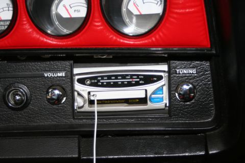 1976 Ford Ranchero - Close-up of a car's interior dashboard, showing gauges and a radio unit.