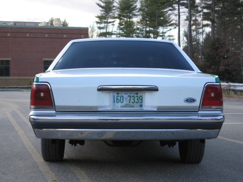 1991 Ford LTD Crown Victoria - Head-on rear view of a white Ford sedan showing twin taillights, chrome bumper and a New Hampshire plate reading 160 7339.