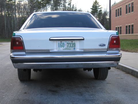 1991 Ford LTD Crown Victoria - Direct rear view of a green-and-white Ford sedan showing the Ford trunk emblem and New Hampshire plate reading 1GO 7339.