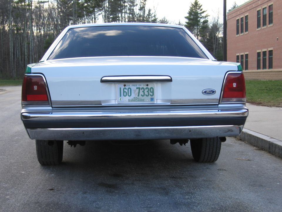 Rear of green and white Ford sedan with NH plate 1GO 7339