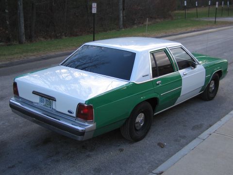 1991 Ford LTD Crown Victoria - Rear driver-side view of the green-and-white Ford sedan showing the trunk, taillights and New Hampshire plate 160 7339.