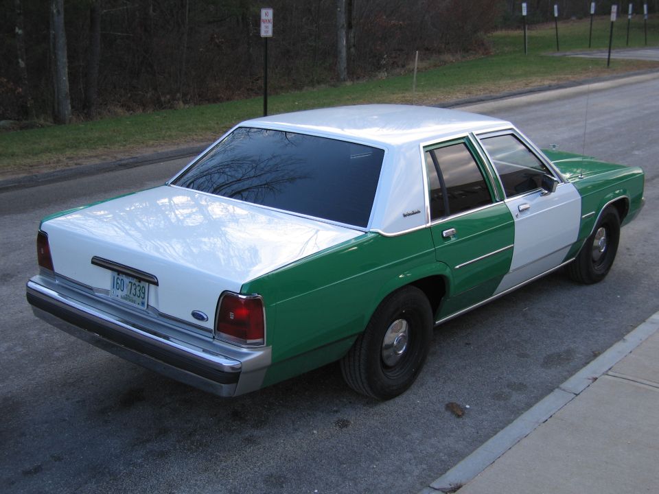 Rear three-quarter view of a green and white Ford LTD Crown Victoria with NH plate