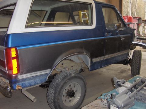 1990 Ford Bronco - This 1990 Ford Bronco is shown from the side while in a shop, possibly during a body re-installation.