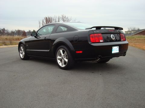 2007 Ford Mustang - Rear view of a black 2007 Ford Mustang coupe, showing its spoiler and custom license plate.