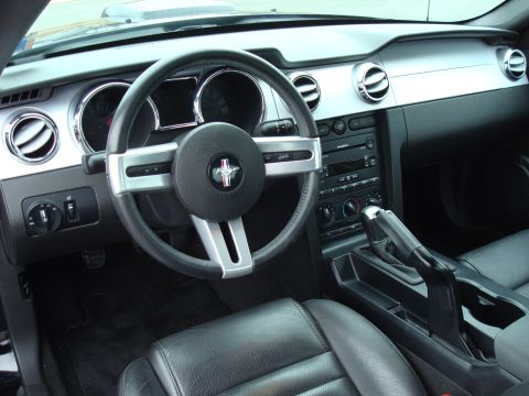 2007 Ford Mustang - The interior of a 2007 Ford Mustang, its distinctive dashboard and steering wheel emblem.