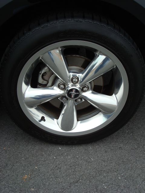 2007 Ford Mustang - Close-up of a chrome wheel with a Mustang emblem on a tire.