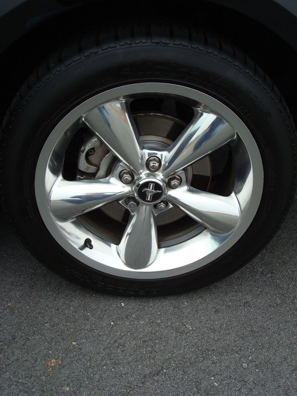 Polished five-spoke Mustang wheel with pony center cap and BFGoodrich g-Force T/A tire