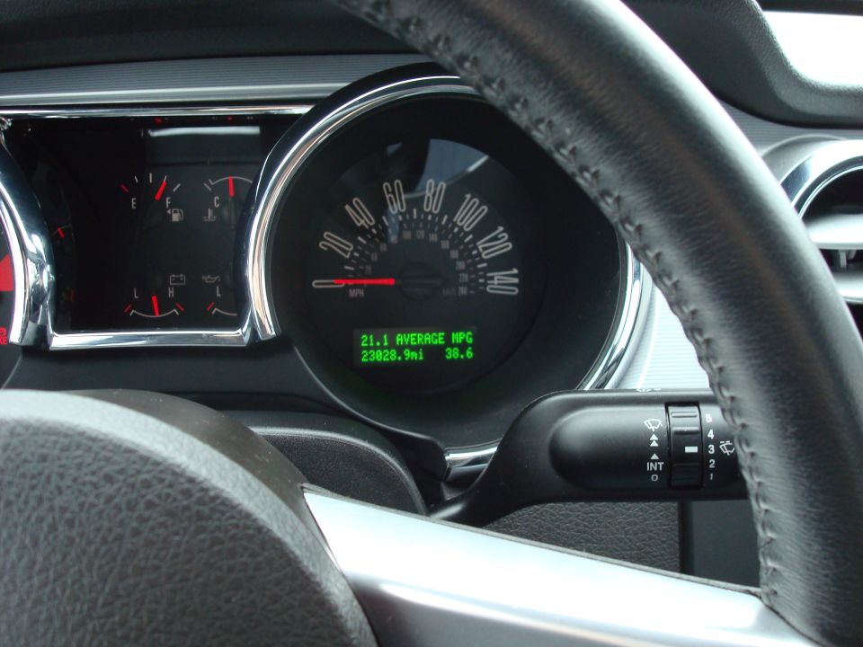 Mustang speedometer and green digital display showing 21.1 avg MPG and 23028.9 mi