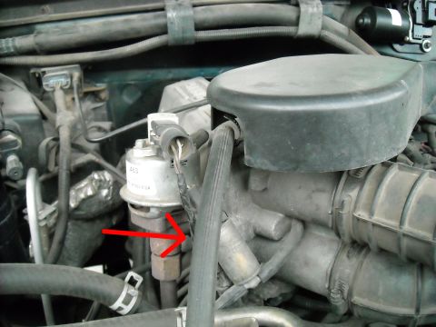 1994 Ford Bronco - Close-up of an engine bay, highlighting a sensor with a red arrow.