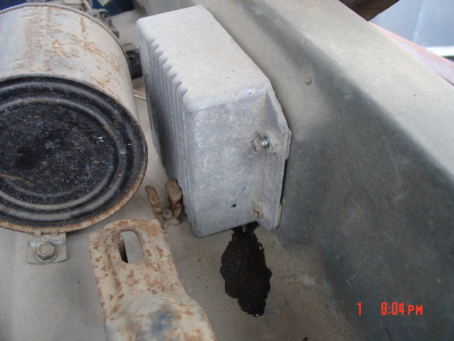 Rusty fuel filter and aluminum cooler bolted under a vehicle body