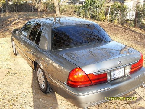 2004 Mercury Marquis - Rear view of a gray sedan with tinted windows and chrome accents.