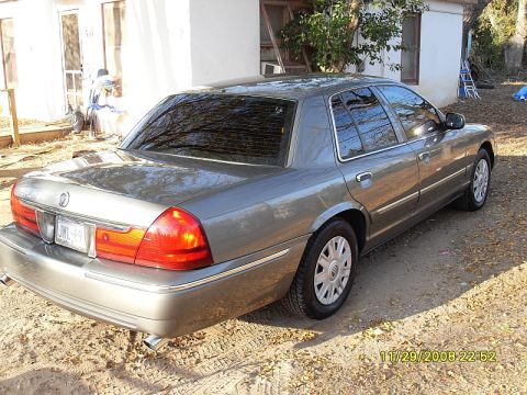 2004 Mercury Marquis - A gray 2004 Mercury Grand Marquis sedan is parked on a dirt lot.