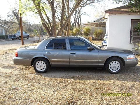2004 Mercury Marquis - Side view of a gray Mercury Grand Marquis sedan parked outdoors.