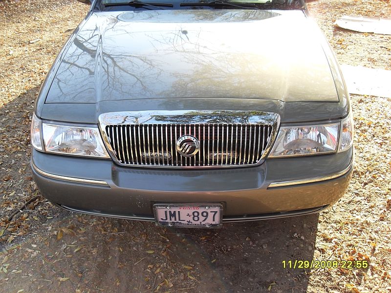 Gray Mercury Grand Marquis front grille and headlights, license plate JML-897 visible