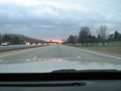 1988 Mercury Grand Marquis - Driving on a highway as the sun sets, with traffic ahead and trees lining the road.
