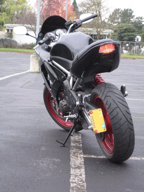 2008 Kawasaki Ninja R - Rear view of a black motorcycle with red wheels and an Oregon license plate parked on asphalt.
