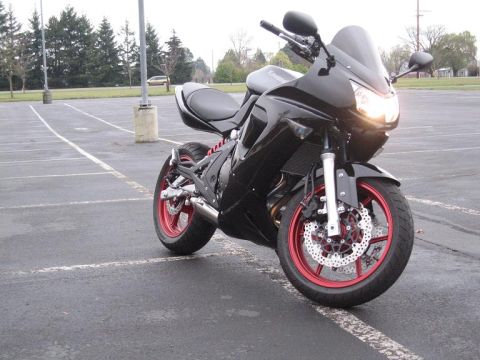 2008 Kawasaki Ninja R - A black Kawasaki motorcycle with red wheels is parked in an empty lot.