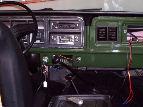 1978 Ford Bronco - The interior of a 1978 Ford Bronco features a green dashboard, a Ford-branded radio, and a floor-mounted shifter.