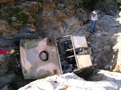 1986 Toyota Hilux - This off-road vehicle has rolled onto its side in a difficult, rocky terrain.