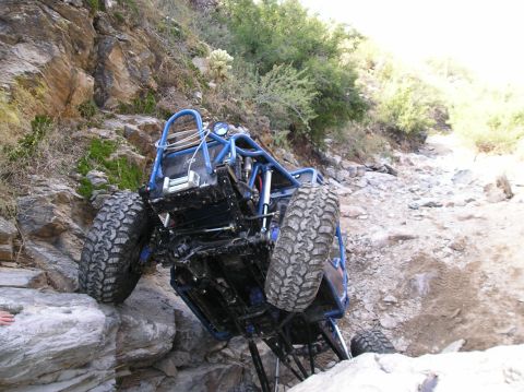 1986 Toyota Hilux - This custom buggy is navigating a challenging rocky incline on an off-road trail.