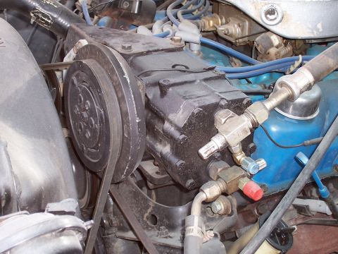 1978 Ford Bronco - Close-up view of an engine's air conditioning compressor and associated plumbing.