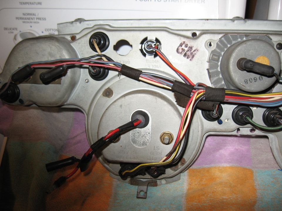 Back of a car's instrument cluster with many wires and connectors