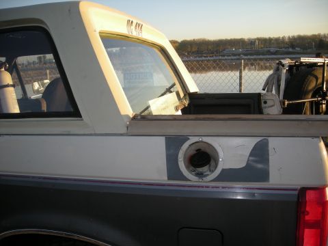1991 Ford Bronco - Rear side view of a 1991 Ford Bronco, showing the UC 4X4 decal and an external fuel filler cap.