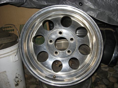 1989 Ford Bronco - A single aluminum alloy wheel with a polished finish and circular cutouts is shown.