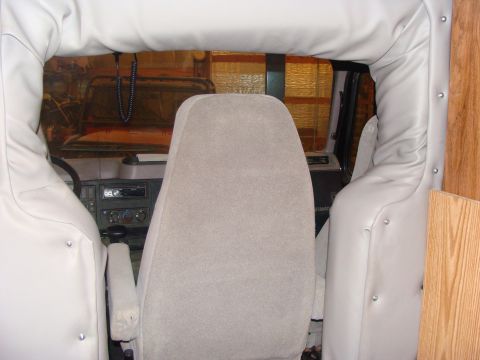 1992 Ford Bronco - Interior view of a vehicle's dashboard and seats, with a beaded string hanging from the rearview mirror.